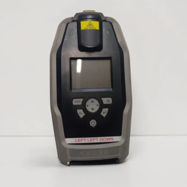 Front view of the Ahura First Defender handheld chemical identification system standing upright on a white surface, featuring its control keypad, LCD screen, laser aperture warning label at the top, and a label reading "LEFT LEFT DOWN".