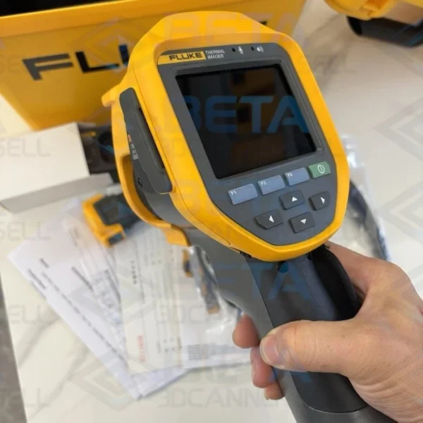 Close-up view of a hand holding the yellow and dark gray Fluke Ti401 PRO handheld thermal imaging camera, displaying its LCD screen, navigation control buttons, and pistol-grip design.
